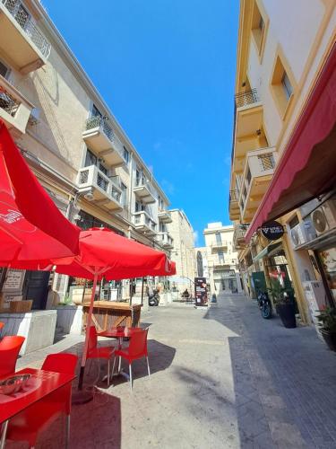 a tables and chairs with red umbrellas on a street at Fellini 8 1/2 in Haifa