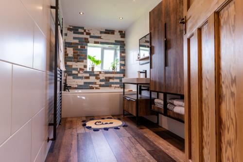a bathroom with a bath tub and a sink at Luxurious Private Accommodation Manchester Airport Stay Park And Fly Lyme Park in Hazel Grove