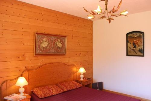 ヴァル・トランスにあるRoc de Peclet Appartements VTIの木製の壁のベッドルーム1室(ベッド1台、ランプ2つ付)