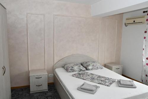 a bedroom with a white bed with two pillows at Apartament Luxury - Promenada Mall in Craiova