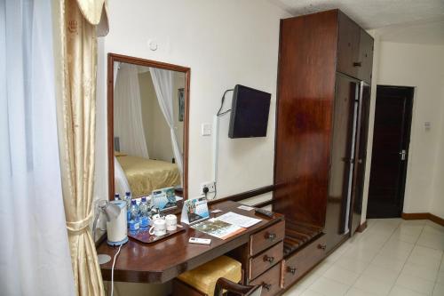 a bathroom with a dressing table and a mirror at North Coast Beach Hotel in Kikambala