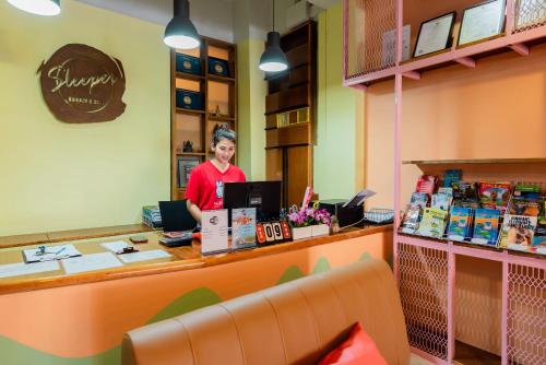 a woman standing behind a counter in a store at Sleeper Hostel in Ao Nang Beach