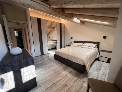 una camera con un grande letto e pavimenti in legno di 029 Trilocale Duplex, Carisolo a Carisolo