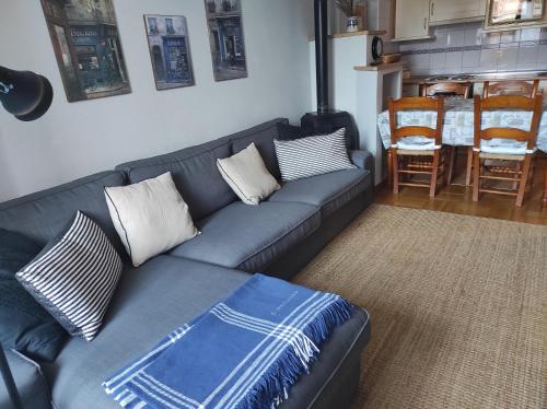 a living room with a blue couch and a kitchen at Dúplex en Parque Europa in Ezcaray