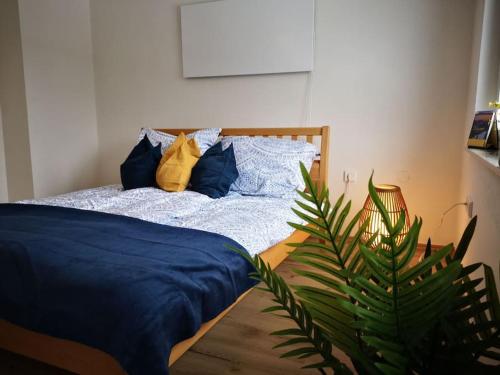 a bedroom with a bed with blue sheets and a plant at Apartment direkt am Weingut Garber in Etzendorf