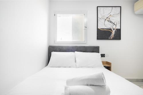阿什杜德的住宿－יחידת דיור ברמת בית מלון עם ממד，卧室配有白色的床和窗户。