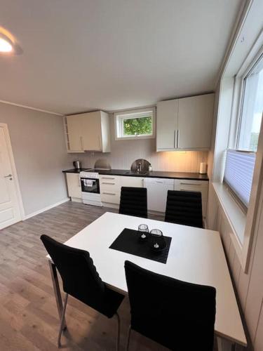 uma cozinha com mesa e cadeiras num quarto em Leilighet sentralt i Svolvær em Svolvær