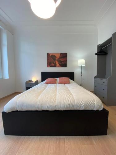 1 dormitorio con 1 cama grande con sábanas blancas en 101 Beffroi, en Thionville