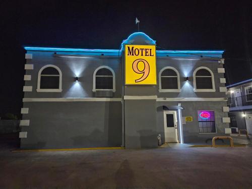 ein Gebäude mit einem Motelschild darauf in der Nacht in der Unterkunft Motel 9 in Laredo