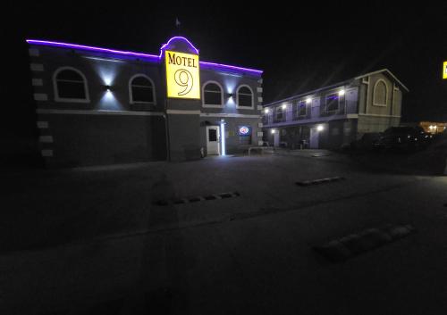 un bâtiment avec un panneau de néon sur lui la nuit dans l'établissement Motel 9, à Laredo