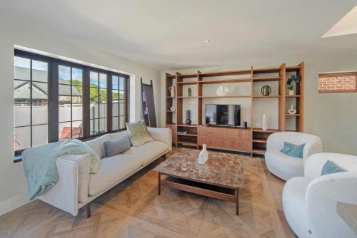 sala de estar con sofá, sillas y mesa en Monaco Poolside Apartment, en Nelson