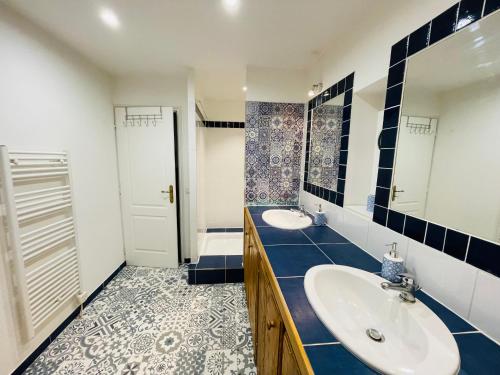 ein Bad mit 2 Waschbecken und blauen und weißen Fliesen in der Unterkunft Le Confidentiel - terrasse et garage privé in Nîmes