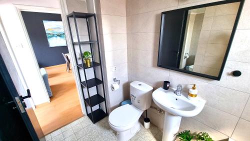 ein Badezimmer mit einem WC, einem Waschbecken und einem Spiegel in der Unterkunft 2 Apts - 12 guests! Comfy and Unique Apt with 150Mbit internet speed in Larnaka