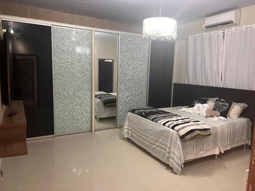 um quarto com uma cama e uma parede de vidro em Casa alto padrão mobiliada em Macapá