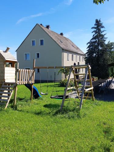 un parque infantil en un patio junto a una casa en Altes Zollhaus, en Hallschlag