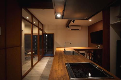 a kitchen with a wooden counter top and a sink at 合い宿すみよし サウナ付 in Fukuoka