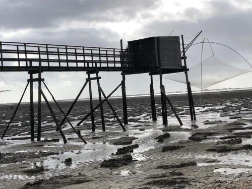 a fishing pier on the beach in the water at Cocon des marais in Bourgneuf-en-Retz