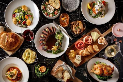 a table with plates of food and glasses of wine at Grand Bohemian Orlando, Autograph Collection in Orlando