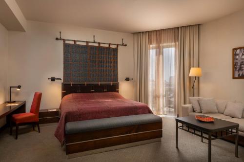 - une chambre avec un lit, un canapé et une table dans l'établissement Tufenkian Historic Yerevan Hotel, à Erevan