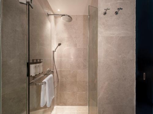 a shower with a glass door in a bathroom at The Robertson House by The Crest Collection in Singapore