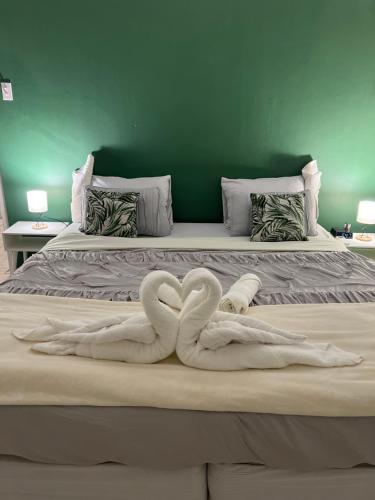 dos cisnes de toalla están sentados en una cama en Villa Grand Jardin en Jan Thiel