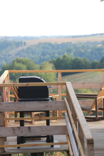 a grill sitting on top of a wooden deck at Pour les amoureux de la nature. in Saint-Cirgue