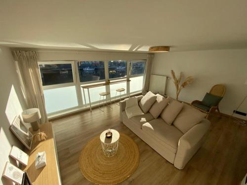 una sala de estar con un sofá y una mesa en L'Essentiel, en Dinant