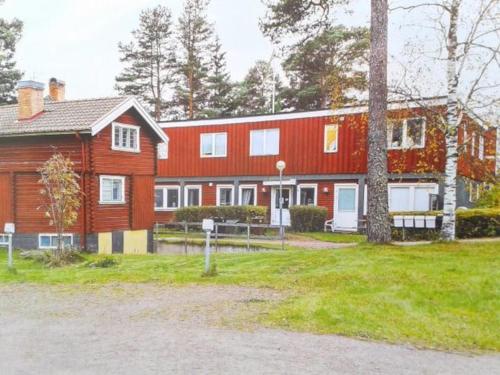 a large red house with a tree in front of it at Hostel Gästhem Glassen Apartment in Rättvik