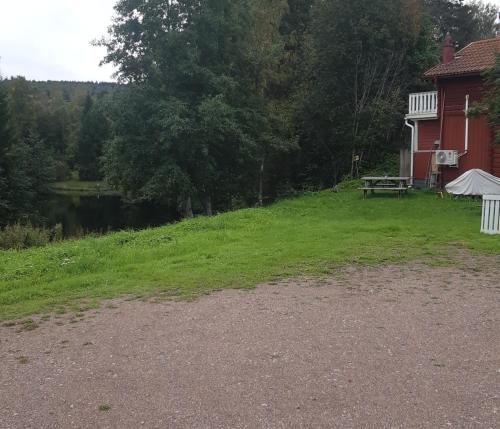 a house with a picnic table next to a lake at Hostel Gästhem Glassen Apartment in Rättvik