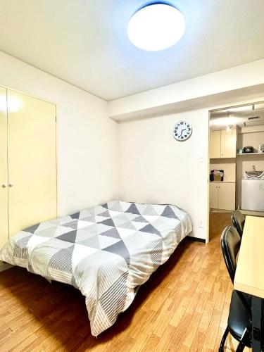 a bedroom with a bed and a clock on the wall at Hotel KinRin in Tokyo
