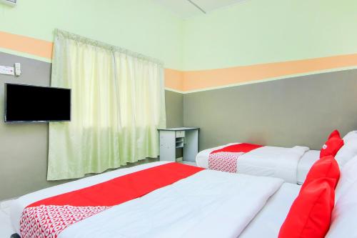 dwa łóżka w pokoju z telewizorem na ścianie w obiekcie Tangkak Mawadahh Inn Stay w mieście Tangkak