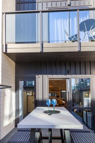 two wine glasses sitting on a table in front of a building at Walk to Riverside Market 4 bed 4 bath with car park in Christchurch