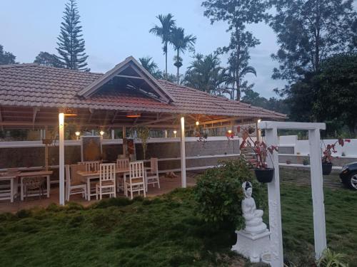 a house with a patio with tables and chairs at Coomaaoon by silversky in Gonikoppal