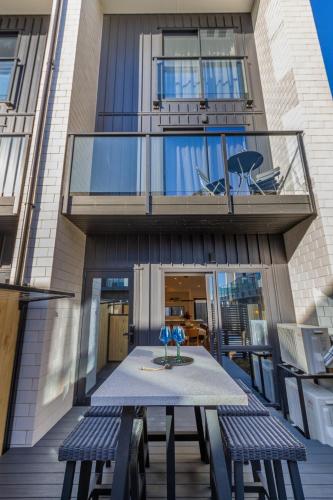 a table and two benches in front of a building at Walk to Riverside Market 4 bed 4 bath with car park in Christchurch