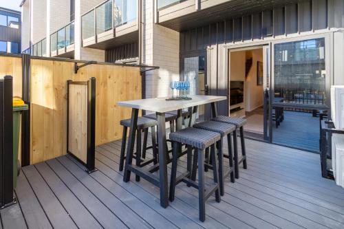a wooden deck with a table and stools on it at Walk to Riverside Market 4 bed 4 bath with car park in Christchurch