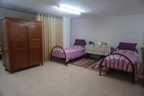 een woonkamer met 2 bedden en een tafel bij Lovely Lama Family House in Bethlehem