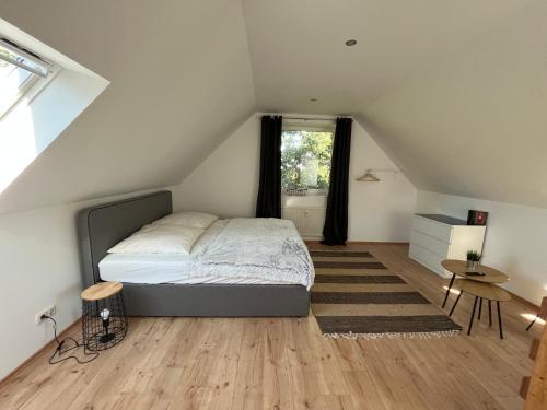 ein Schlafzimmer mit einem Bett im Dachgeschoss in der Unterkunft Deich Connect 9.4 in Dorum Neufeld