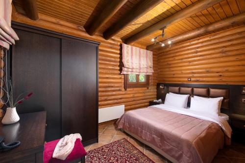a bedroom with a bed in a wooden cabin at Natura Chalets in Méga Khoríon