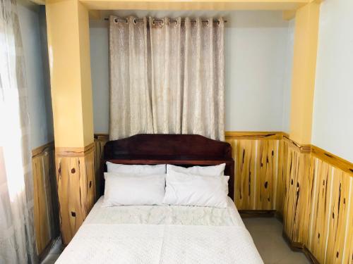 um pequeno quarto com uma cama e uma janela em Baguio Classic Cozy Home em Baguio