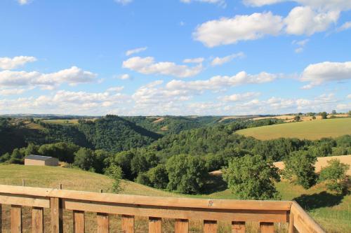 a wooden fence with a view of the countryside at Pour les amoureux de la nature. in Saint-Cirgue