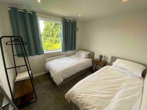 a bedroom with two beds and a window at Spacious Contemporary Home in Leeds