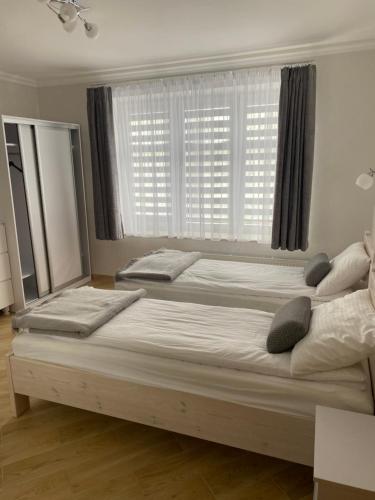 een slaapkamer met 2 bedden voor een raam bij Pokoje gościnne Orlovo DT in Gdynia
