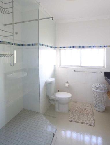 a white bathroom with a toilet and a shower at 602 MARBELLA UMHLANGA DURBAN in Durban