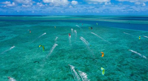 a group of people flying kites in the ocean at C Rodrigues Mourouk in Rodrigues Island