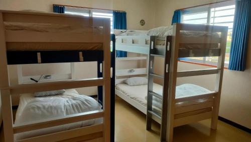 two bunk beds in a room with a window at SumiwaHouse 一棟貸プラン in Yomitan