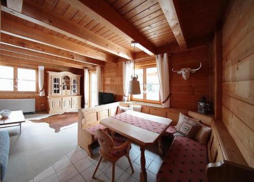 ネッセルヴァンクにあるFeriendorf Reichenbach - Bgm.-Martin-Str. 12のテーブルとソファ、テーブルと椅子のある木造の部屋