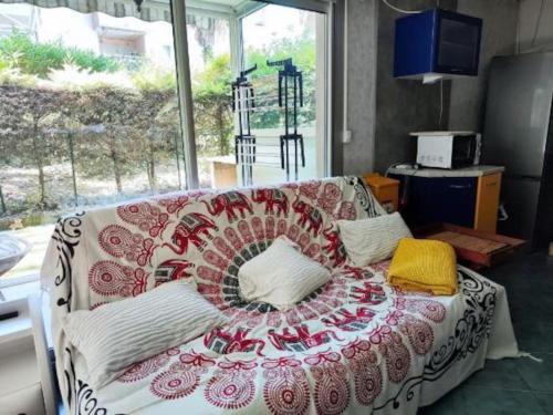 - un canapé avec une couverture dans le salon dans l'établissement appartement rez de jardin 6 personnes cagnes sur mer 06 piscine et tennis, à Cagnes-sur-Mer