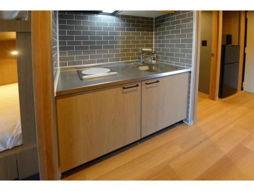 a kitchen with a sink and a brick wall at THE BONDS HOTEL TOKYO - Vacation STAY 48446v in Tokyo