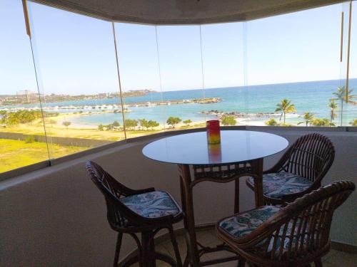 a table and chairs in a room with a view of the ocean at Esparta Suite isla de margarita in Porlamar