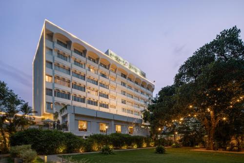 um grande edifício branco com árvores em frente em Southern Star,Mysore em Mysore